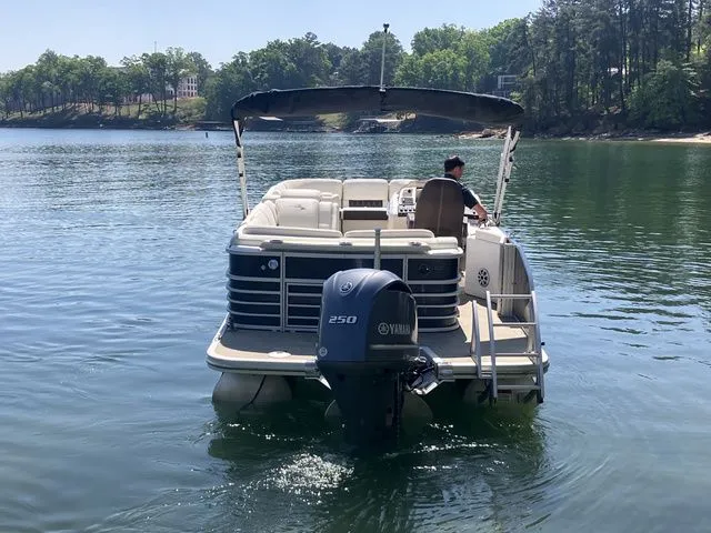 Slide: The Image of 2019 Bennington 23 QLC pontoon boat on a serene lake. - 6