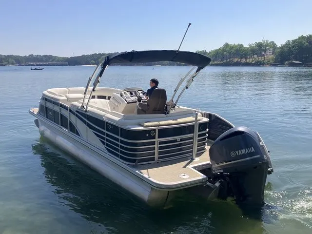 Slide: The Image of 2019 Bennington 23 QLC pontoon boat on a serene lake. - 7