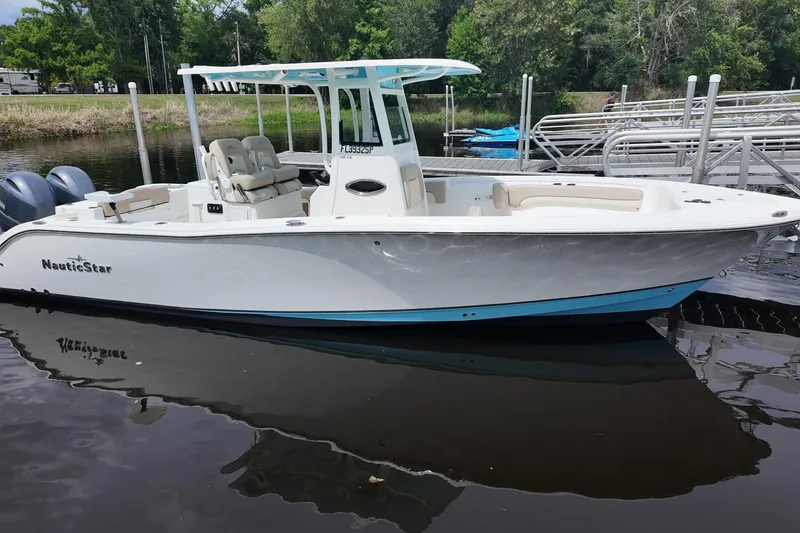 The Image of 2026 NAUTIC STAR 28 XS boat docked on calm water, showcasing sleek design. - 0