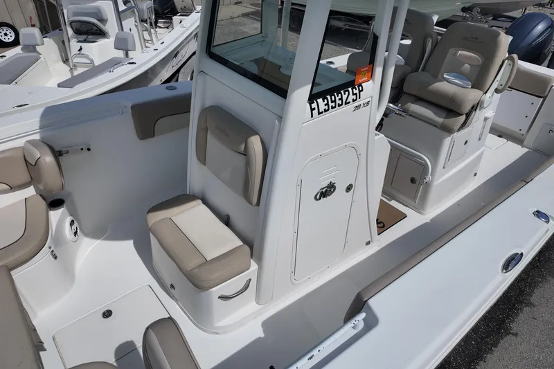 Slide: The Image of 2026 NAUTIC STAR 28 XS boat interior with beige seating and console. - 13