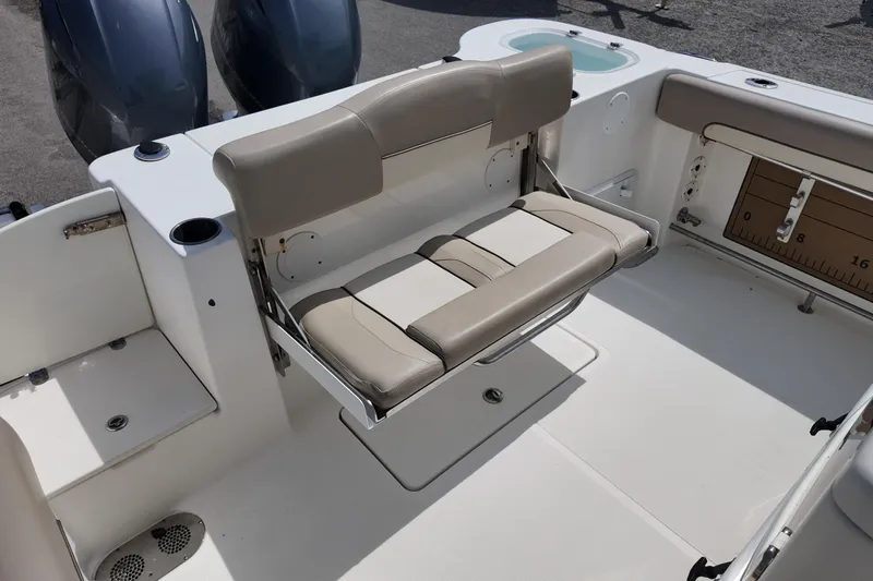 Slide: The Image of 2026 NAUTIC STAR 28 XS boat interior with beige seating and dual engines. - 17