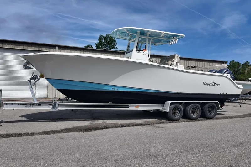 Slide: The Image of 2026 NAUTIC STAR 28 XS boat on trailer, parked outdoors. - 2