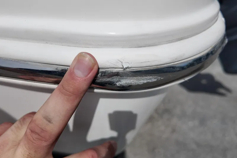 Slide: The Image of Close-up of a 2026 NAUTIC STAR 28 XS boat with a finger pointing at hull damage. - 21