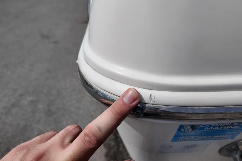 Slide: The Image of Finger pointing at scratch on 2026 NAUTIC STAR 28 XS boat hull. - 22