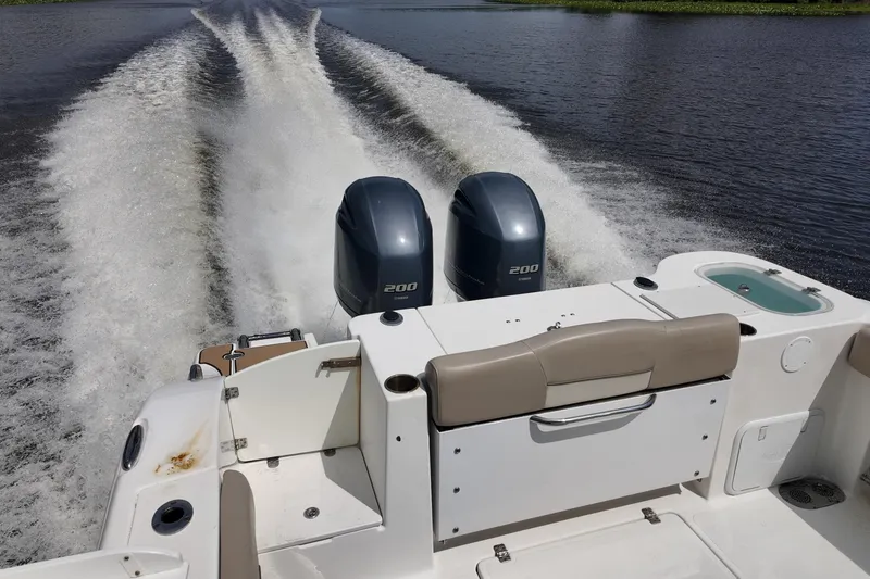 Slide: The Image of 2026 NAUTIC STAR 28 XS boat with dual 200 horsepower engines cruising on water. - 4
