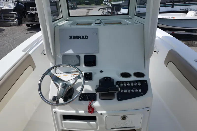 Slide: The Image of 2026 NAUTIC STAR 28 XS boat dashboard with steering wheel and Simrad display. - 8