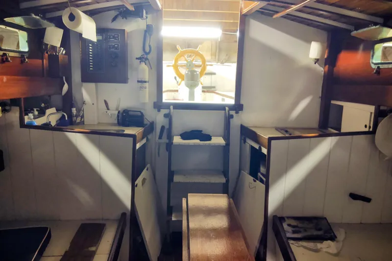 Slide: The Image of Interior of a 1965 Friendship Sloop, showcasing wooden cabinetry and nautical equipment. - 3