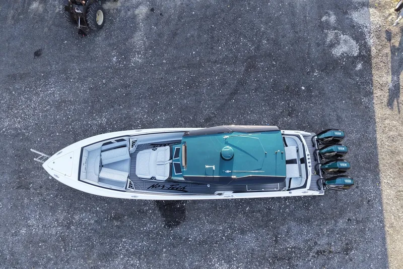 Slide: The Image of Aerial view of 2024 Nor-Tech 400 Supersport boat with four engines on gravel surface. - 10