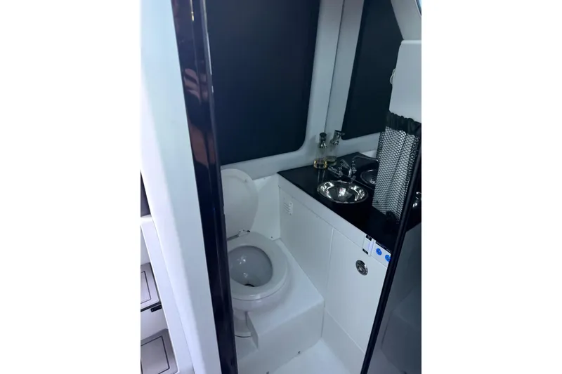 Slide: The Image of 2024 Nor-Tech 400 Supersport boat bathroom with toilet and sink. - 27