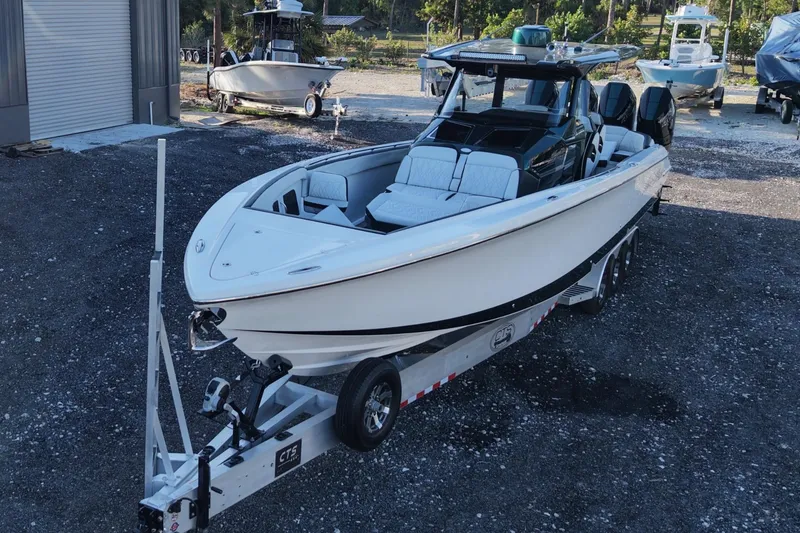 Slide: The Image of 2024 Nor-Tech 400 Supersport boat on trailer, parked outdoors near other boats. - 3