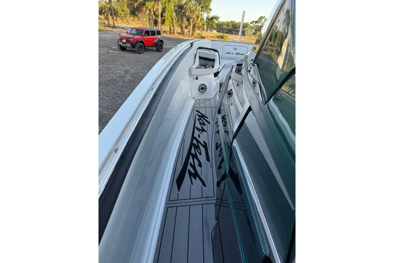 Slide: The Image of 2024 Nor-Tech 400 Supersport boat with sleek design, parked near a red vehicle. - 30