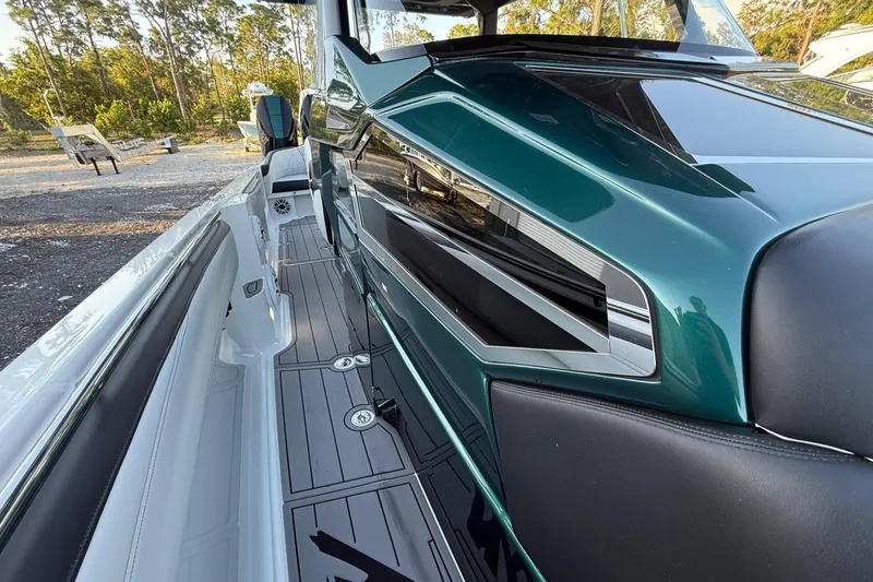 Slide: The Image of 2024 Nor-Tech 400 Supersport boat, sleek design with modern detailing, docked outdoors. - 31