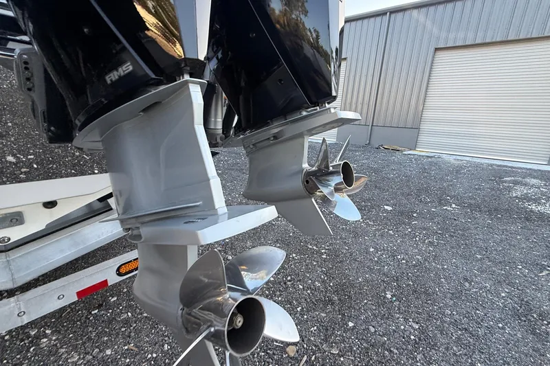 Slide: The Image of 2024 Nor-Tech 400 Supersport boat engines with dual propellers, parked near a metal building. - 35