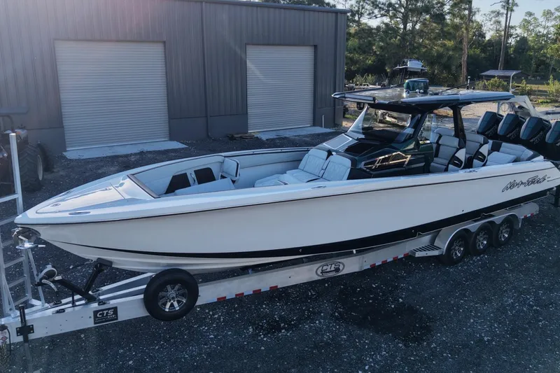 Slide: The Image of 2024 Nor-Tech 400 Supersport boat on trailer, parked outside a warehouse. - 4