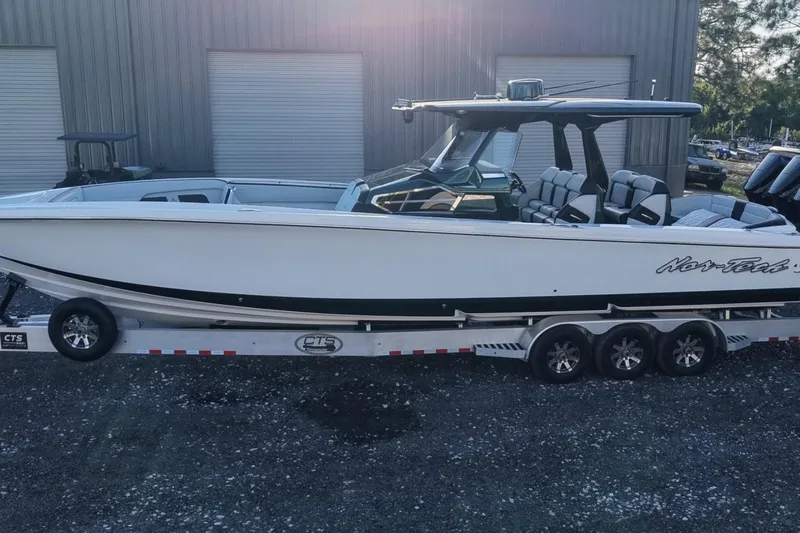 Slide: The Image of 2024 Nor-Tech 400 Supersport boat on trailer, sleek design, parked outdoors. - 6