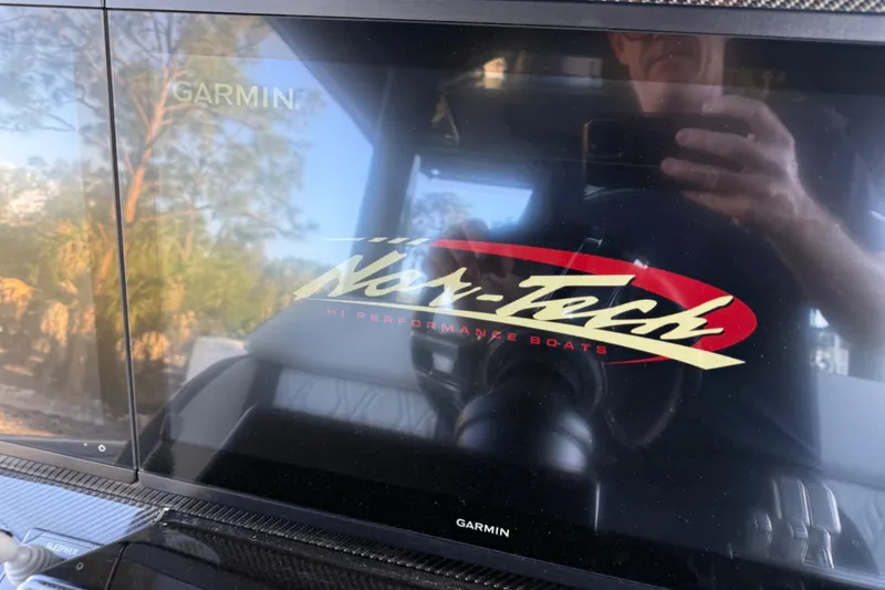 Slide: The Image of Garmin display on 2024 Nor-Tech 400 Supersport boat, reflecting outdoor scenery. - 63