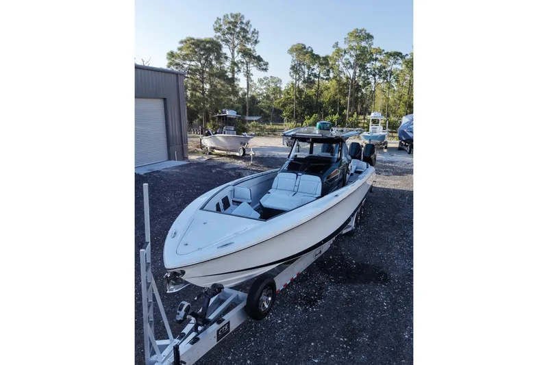 Slide: The Image of 2024 Nor-Tech 400 Supersport boat on trailer, parked outdoors with trees in background. - 7