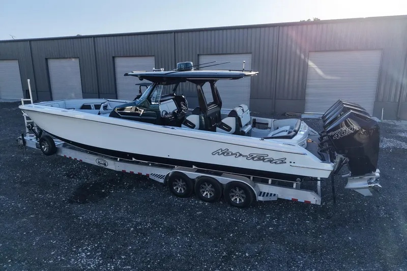 Slide: The Image of 2024 Nor-Tech 400 Supersport boat on trailer, parked outside industrial building. - 8