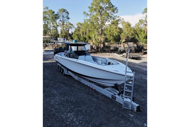 Slide: The Image of 2024 Nor-Tech 400 Supersport boat on trailer, surrounded by trees and gravel. - 9
