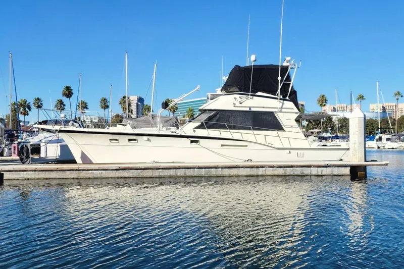Slide: The Image of 1978 Hatteras 45 Express Sportfish yacht docked in a marina under clear blue skies. - 1