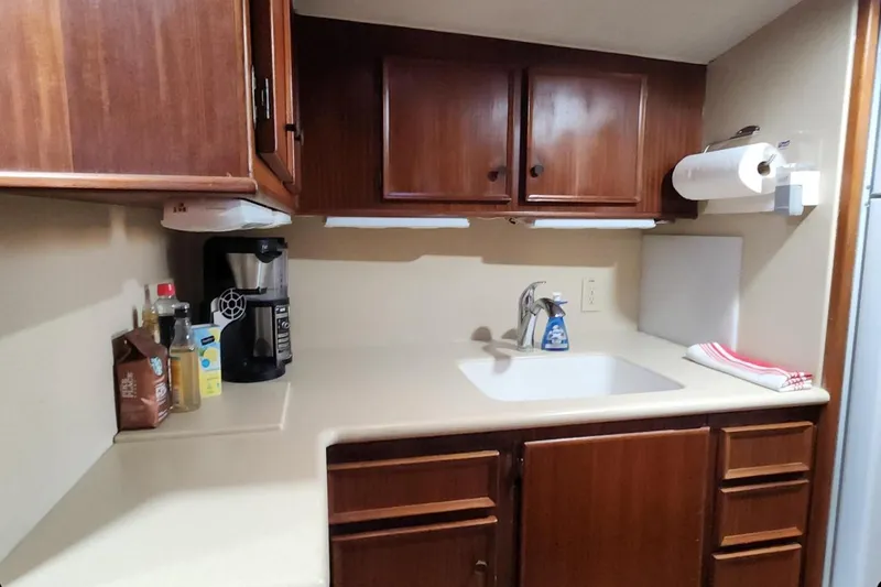 Slide: The Image of 1978 Hatteras 45 Express Sportfish galley with wooden cabinets and countertop appliances. - 14