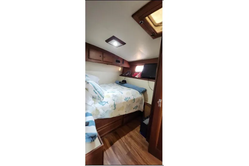 Slide: The Image of Cozy cabin interior of 1978 Hatteras 45 Express Sportfish with bed and wooden cabinetry. - 19