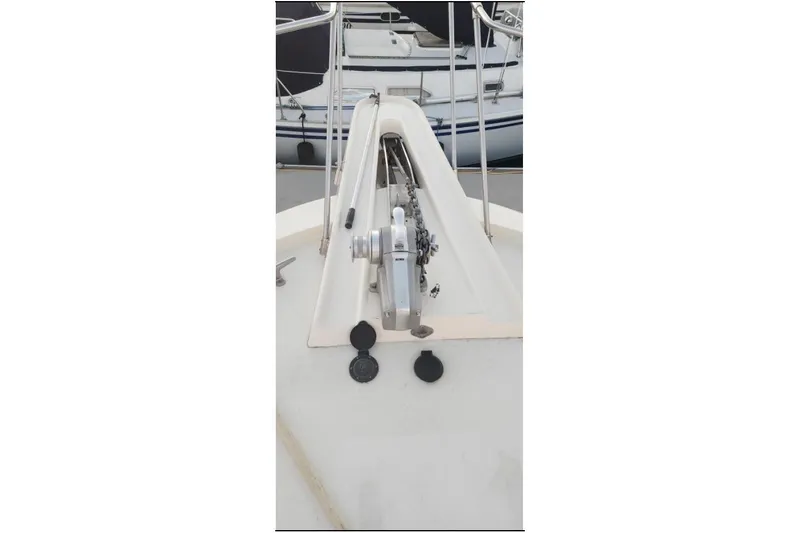 Slide: The Image of 1978 Hatteras 45 Express Sportfish boat deck with anchor winch and railing. - 21
