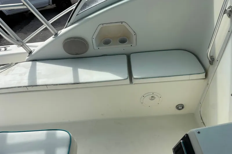 Slide: The Image of Interior seating of a 1998 Hydrocat 300X boat with white cushions and cup holders. - 13