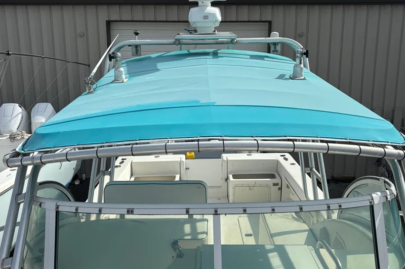 Slide: The Image of 1998 Hydrocat 300X boat with turquoise canopy and sleek design in a marina setting. - 16