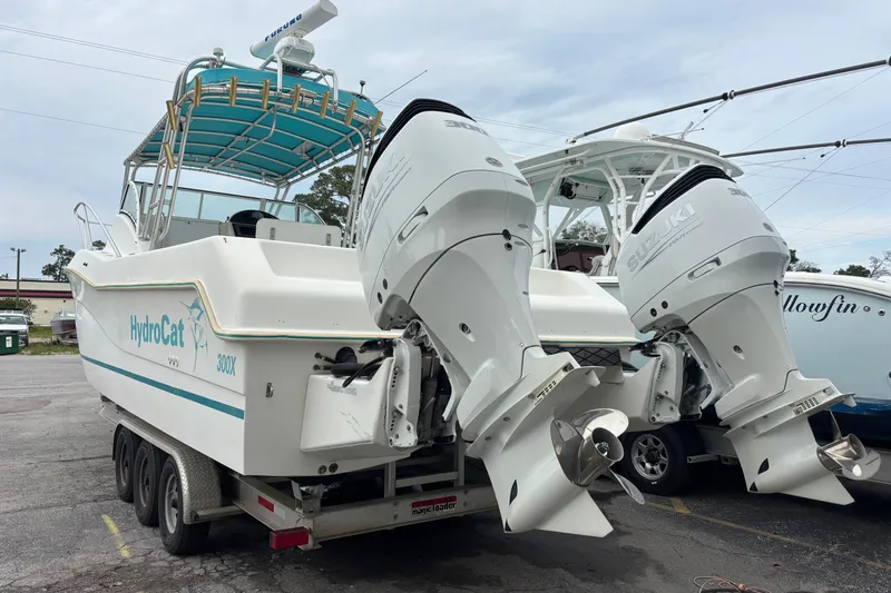Slide: The Image of 1998 Hydrocat 300X boat with twin Suzuki outboard engines on a trailer. - 4