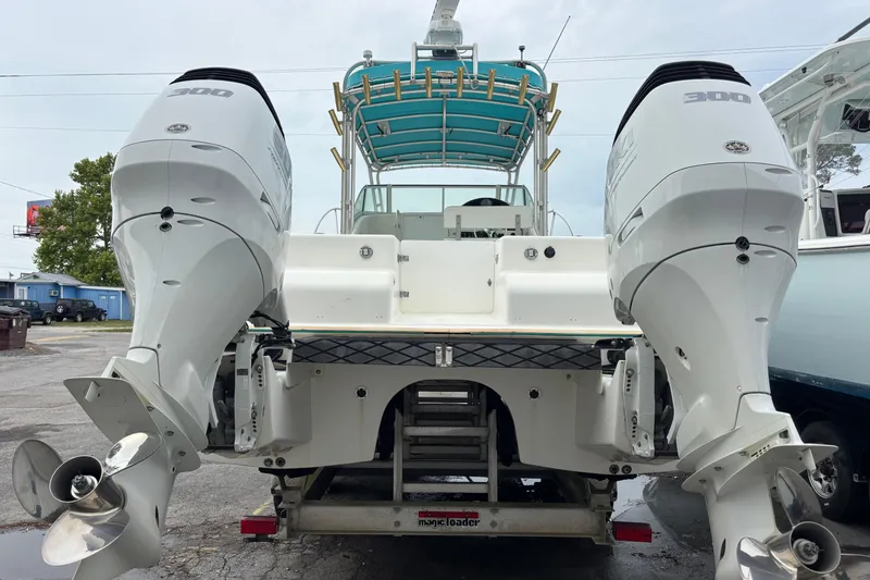 Slide: The Image of 1998 Hydrocat 300X boat with dual outboard engines, docked on a trailer. - 5
