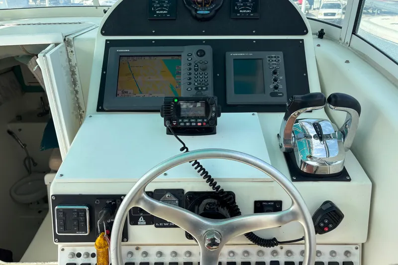 Slide: The Image of Control panel of a 1998 Hydrocat 300X boat with navigation equipment and steering wheel. - 8