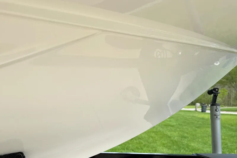 Slide: The Image of Close-up of a 2020 Axis A20 boat hull with a grassy background. - 12