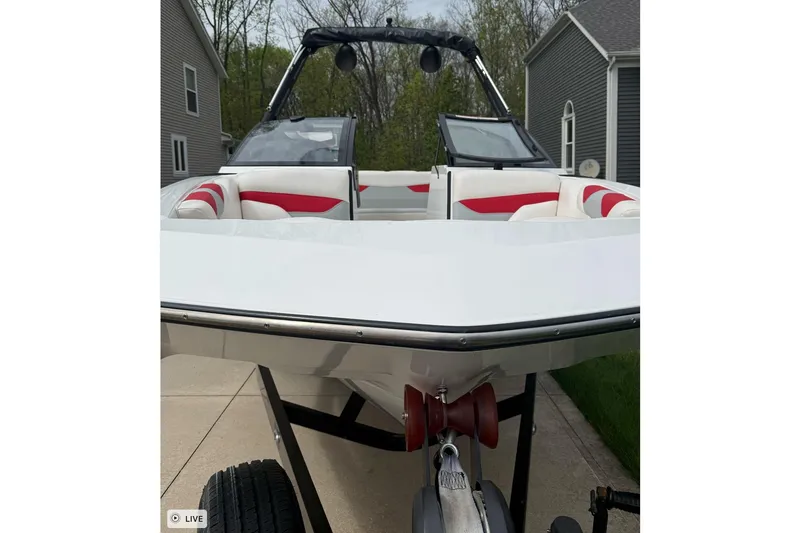 Slide: The Image of 2020 Axis A20 boat on trailer, featuring sleek design and red-accented interior. - 6