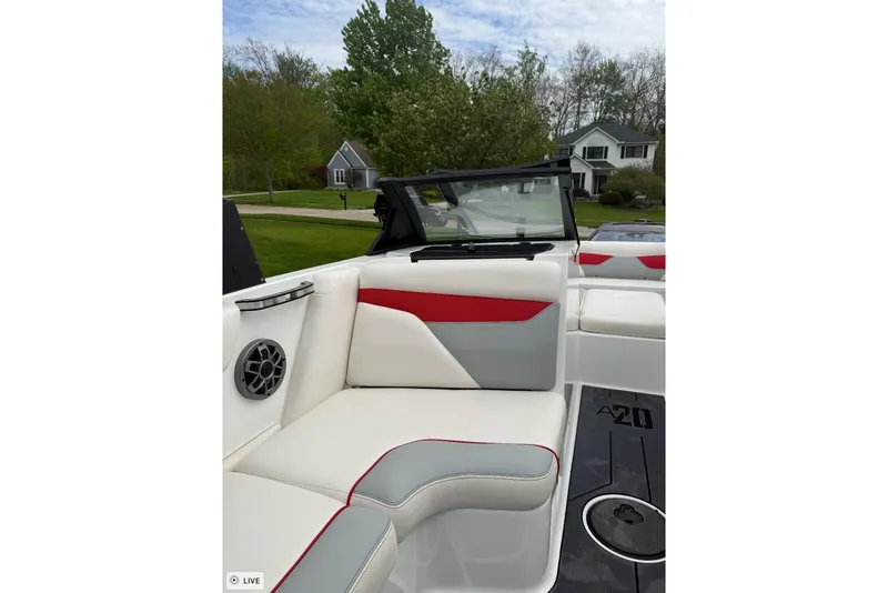 Slide: The Image of 2020 Axis A20 boat interior with red and gray seating, speaker, and windshield. - 7