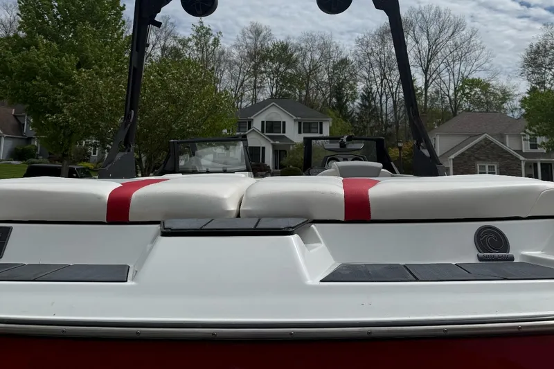Slide: The Image of 2020 Axis A20 boat with red and white seating, parked in a residential area. - 8