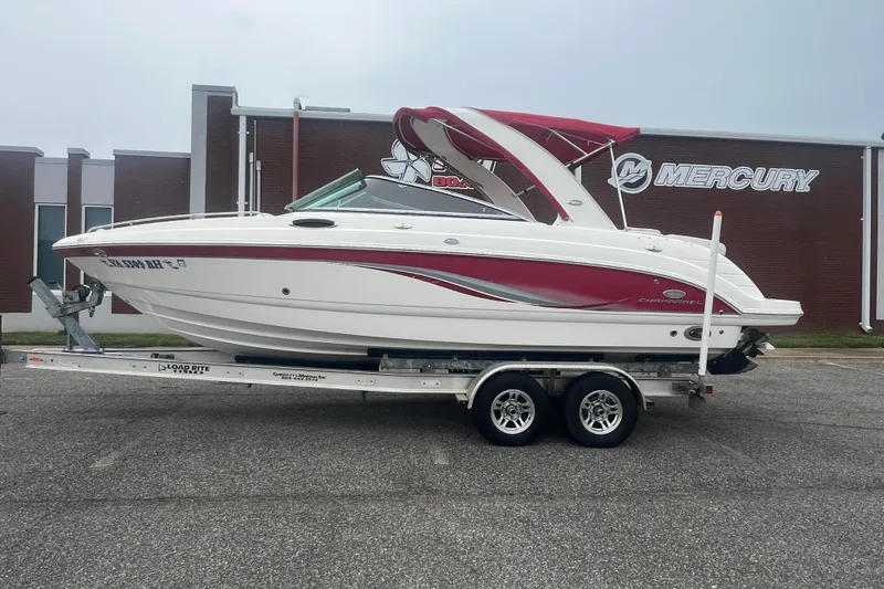 Slide: The Image of 2006 Chaparral 256 SSi boat on trailer, red and white design, parked near Mercury building. - 2
