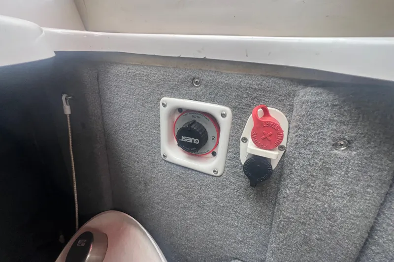 Slide: The Image of 2006 Chaparral 256 SSi boat battery switch and control panel on carpeted interior. - 32