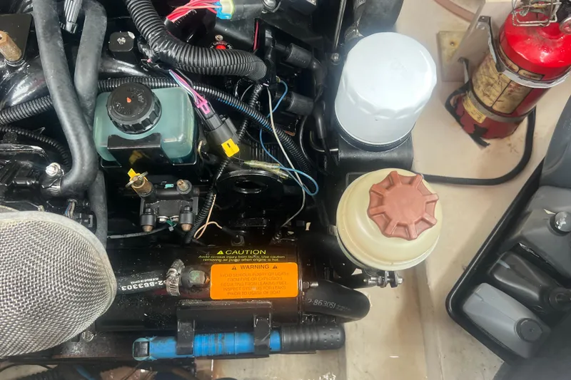 Slide: The Image of Engine compartment of a 2006 Chaparral 256 SSi boat, featuring various components and wiring. - 39