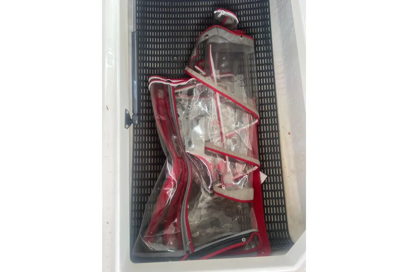 Slide: The Image of Clear plastic and red canvas cover in Chaparral 256 SSi boat storage compartment. - 43