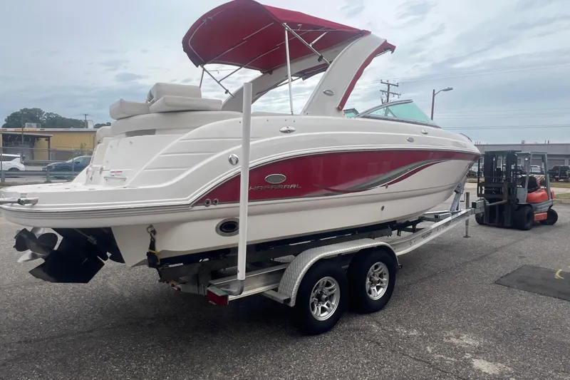 Slide: The Image of 2006 Chaparral 256 SSi boat with red accents on a trailer, parked outdoors. - 8