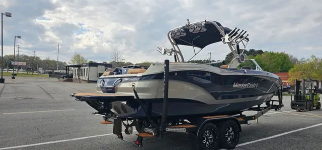 Slide: The Image of 2020 MasterCraft X24 boat parked on trailer outdoors. - 5