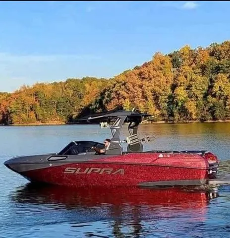 The Image of 2023 Supra SL550 boat on a serene lake in autumn. - 1