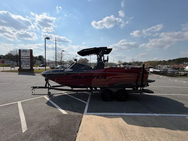 Slide: The Image of 2023 Supra SL550 boat parked on a trailer outdoors. - 10
