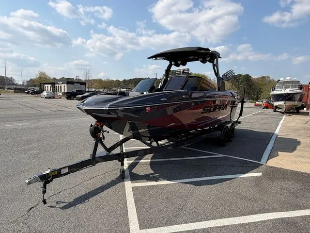 Slide: The Image of 2023 Supra SL550 boat parked on trailer outdoors. - 11