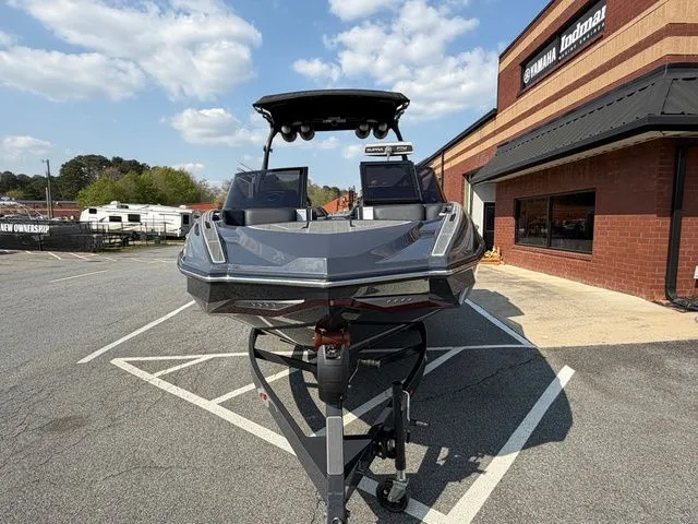 Slide: The Image of 2023 Supra SL550 boat on trailer in front of a building. - 12