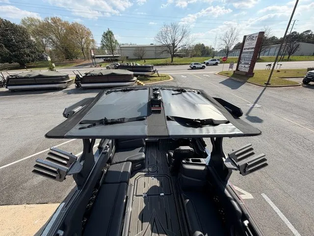 Slide: The Image of 2023 Supra SL550 boat with open canopy on parking lot. - 19