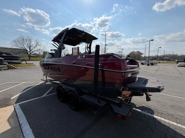 Slide: The Image of 2023 Supra SL550 boat parked outdoors on a trailer. - 9