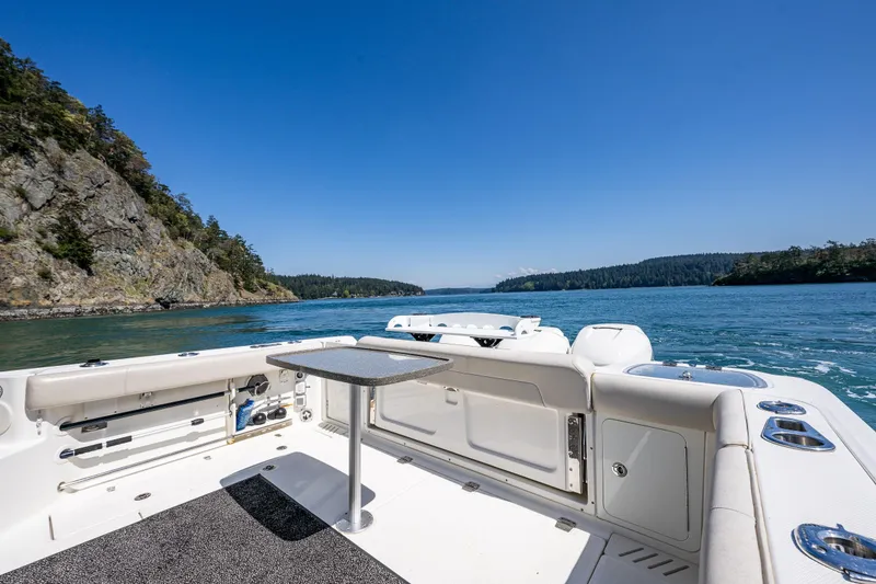Slide: The Image of 2019 Boston Whaler 345 Conquest boat on scenic waterway with rocky shoreline. - 7