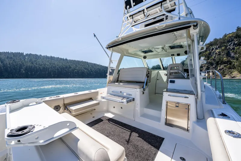 Slide: The Image of 2019 Boston Whaler 345 Conquest boat interior with scenic water and forest backdrop. - 9